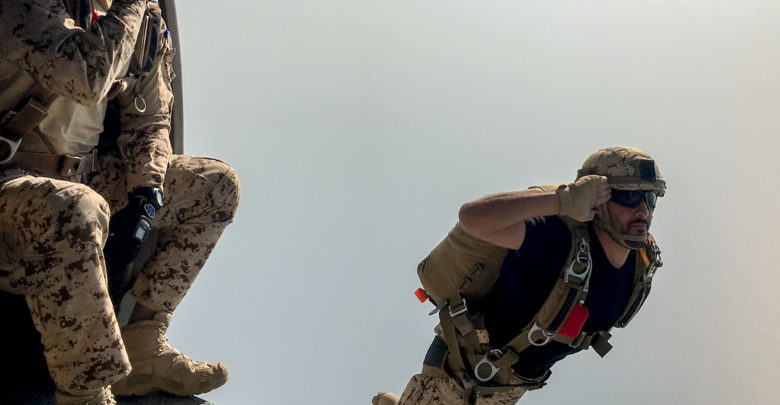 Bahrain Defense Forces paratrooper salutes as he jumps