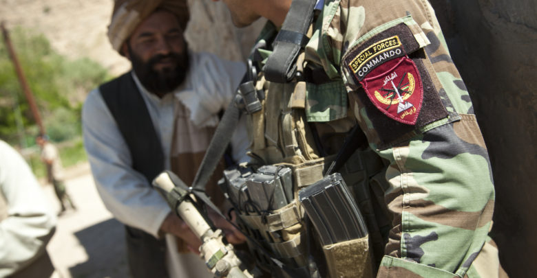 An Afghan National Army special forces soldier, right, talks with a potential Afghan Local Police candidate in Helmand province, Afghanistan