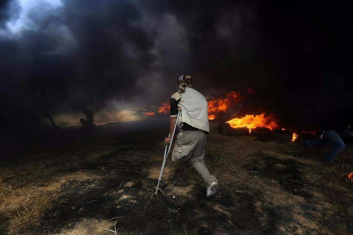 A Palestinian man in Gaza approaches a tire fire