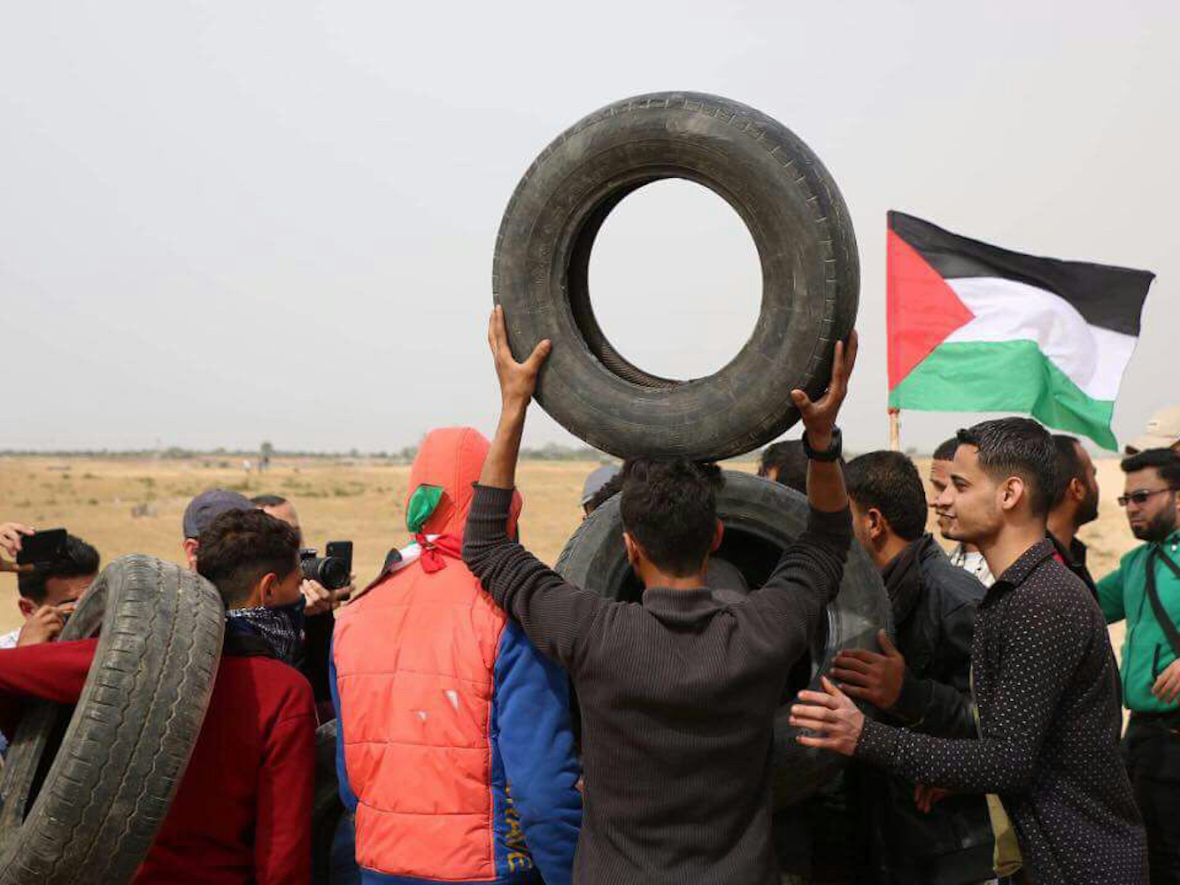 A group of young men in Gaza prepare to light tires on fire ahead of a protest