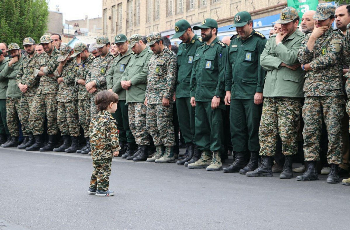 Islamic Revolutionary Guard Corps officers in tears as they look at the son of one of their colleagues, Akbar Zavar Jannati, who was killed in an airstrike in Syria