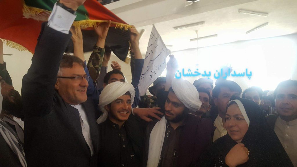 The governor of Afghanistan's Badghis province, Jamaluddin Ishaq, poses with civilians and Taliban fighters