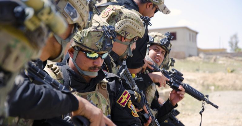 Iraqi Counter Terrorism troops inspect their weapons before conducting a cordon and search training exercise outside Mosul, Iraq