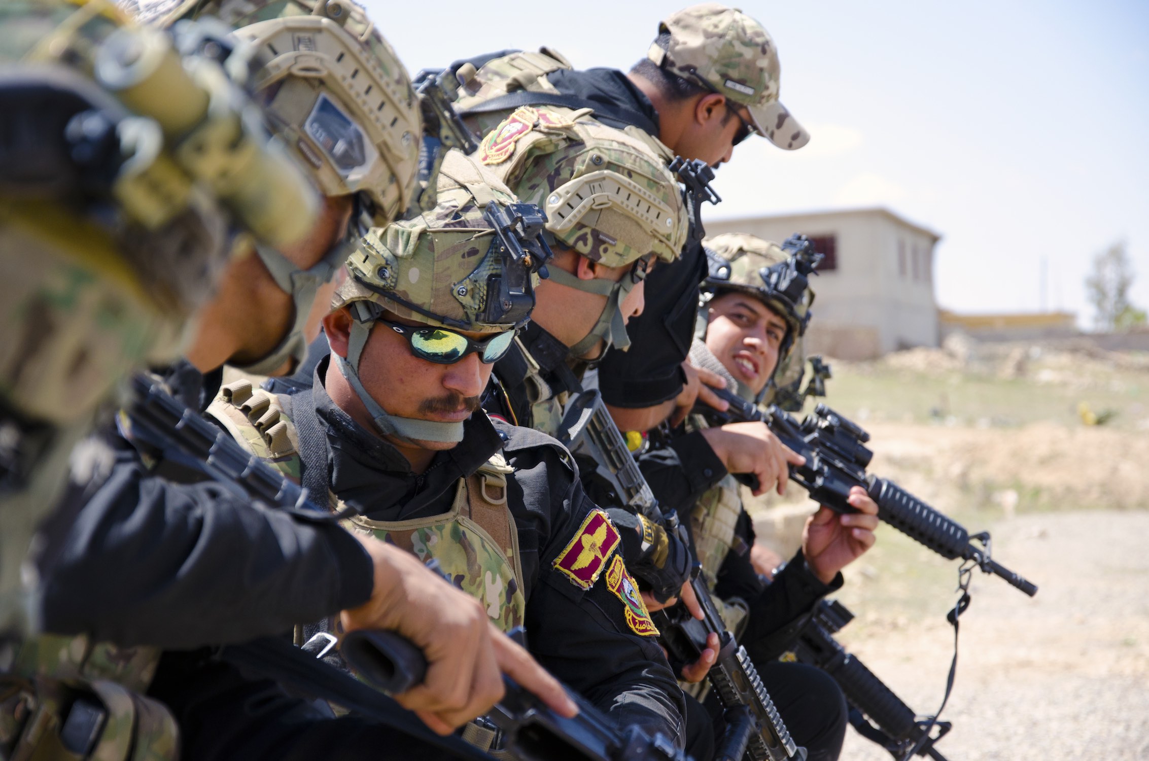 Iraqi Counter Terrorism troops inspect their weapons before conducting a cordon and search training exercise outside Mosul, Iraq