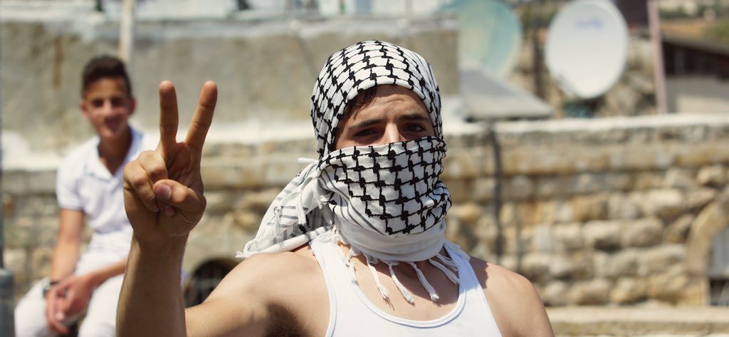 A Palestinian rock thrower poses as clashes break out over al-Aqsa mosque in east Jerusalem