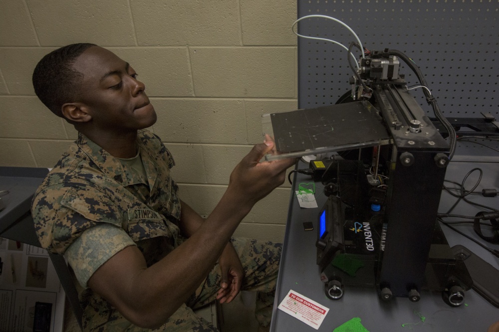A U.S. Marine demonstrates how to use a 3d printer