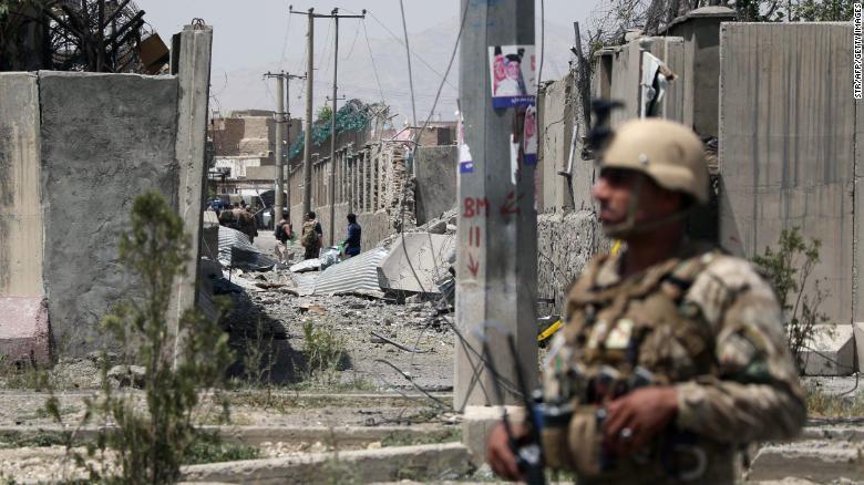 An Afghan security personnel stands guard at the site where a Taliban car bomb detonated at the entrance of a police station in Kabul, August 2019.