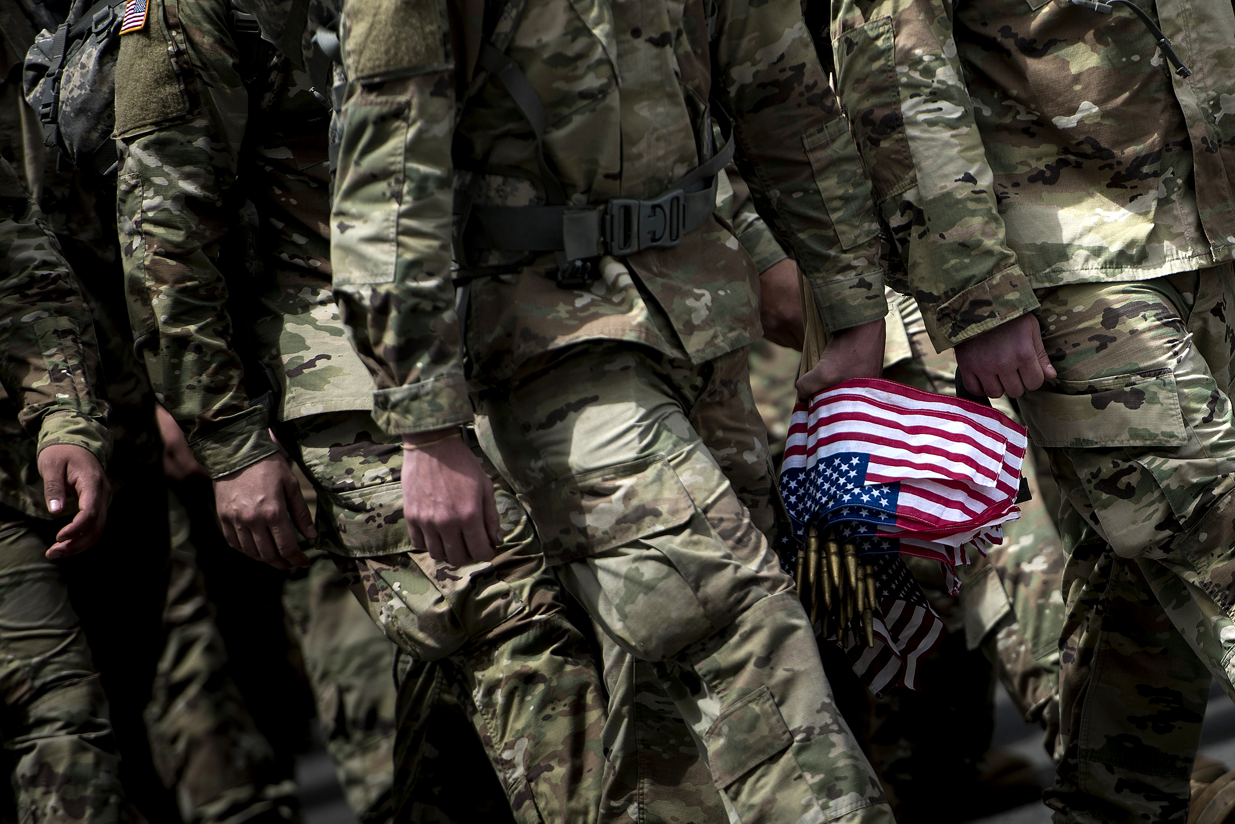 Soldiers in the Old Guard arrive to place flags at graves in Arlington National Cemetery during 