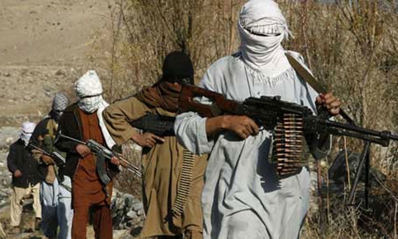 Taliban fighters patrol an area in rural Afghanistan