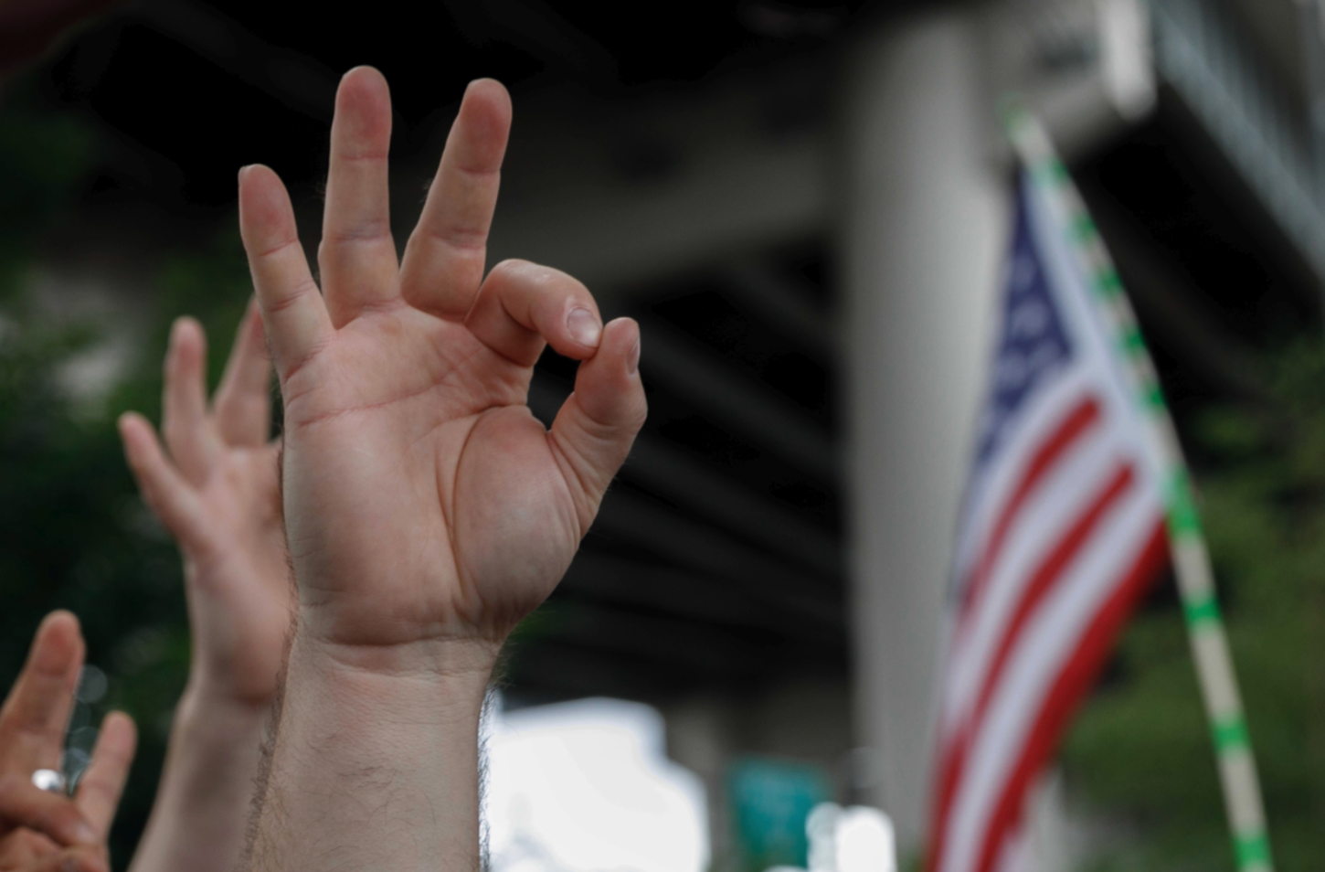 A demonstrator makes a hand gesture believed to have white supremacist connotations, Aug. 17, 2019, in Portland, Oregon, United States