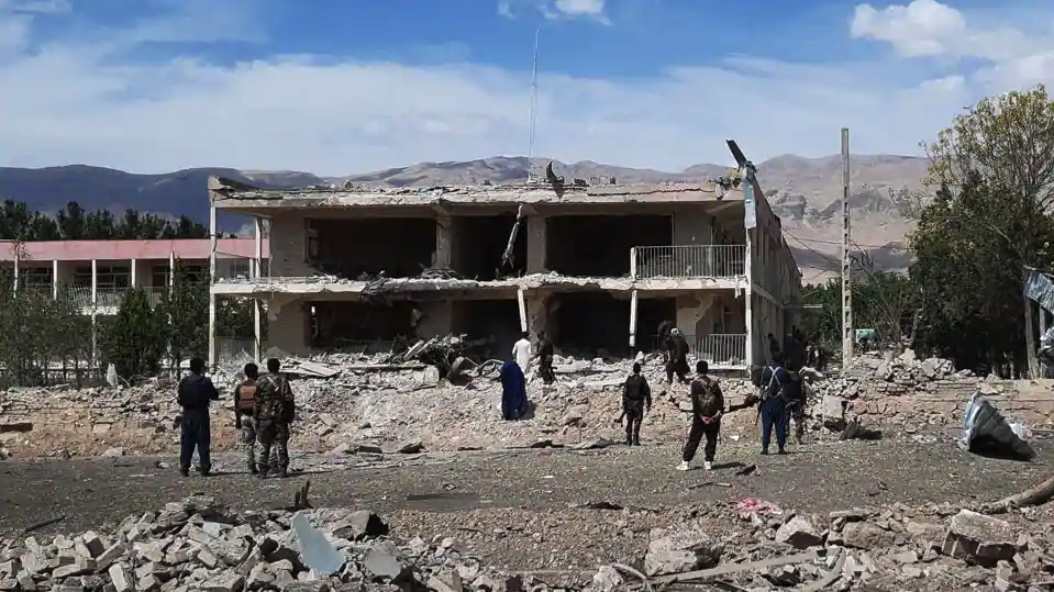 Afghan security personnel inspect the site of a car bomb blast near the destroyed office building of Afghanistan's intelligence agency in the city of Aybak on July 13, 2020