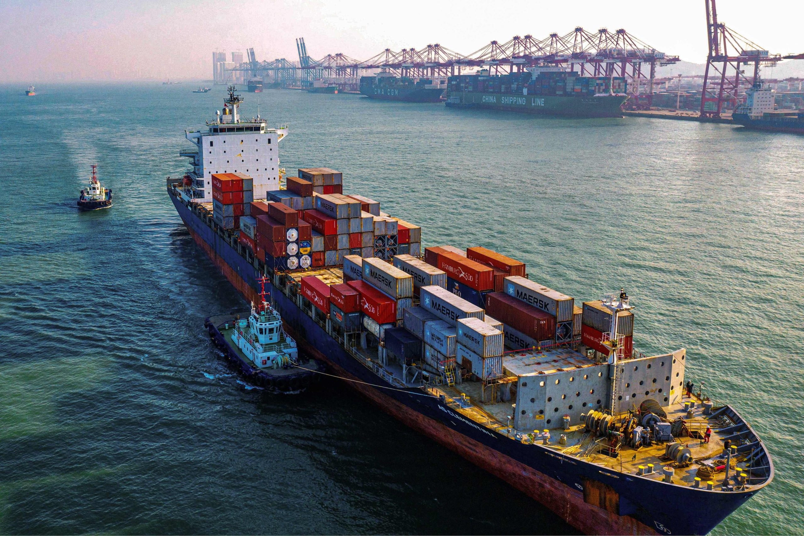 Chinese cargo ship sails through the water as it carries crates. 