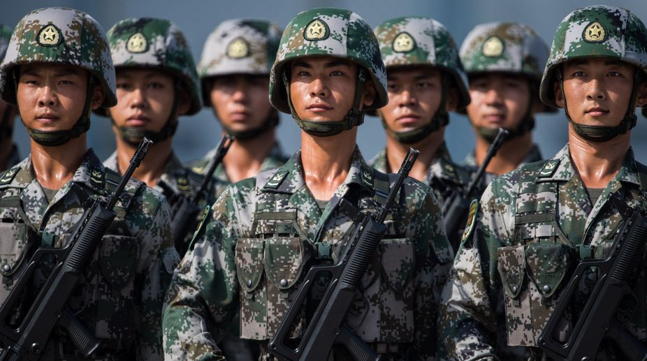 Chinese soldiers look on.