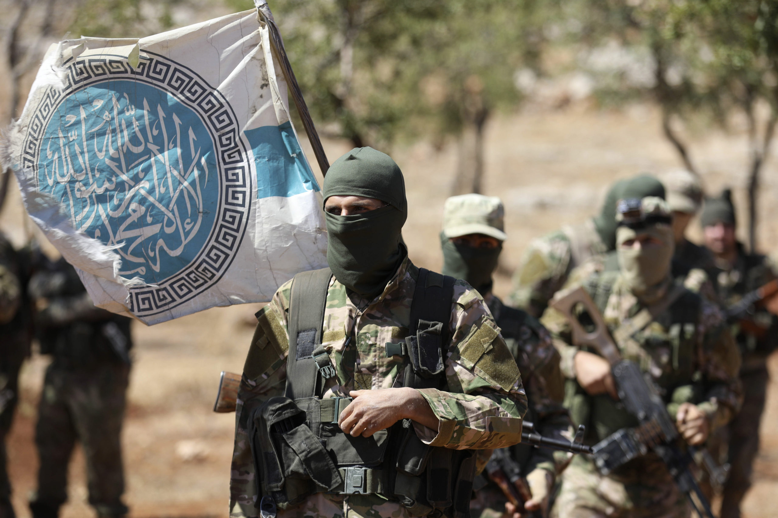 Syrian fighters attend a mock battle in anticipation of an attack by the regime on Idlib province and the surrounding countryside, during a graduation of new Hayat Tahrir al-Sham (HTS) members at a camp in the countryside of the northern Idlib province on August 14, 2018