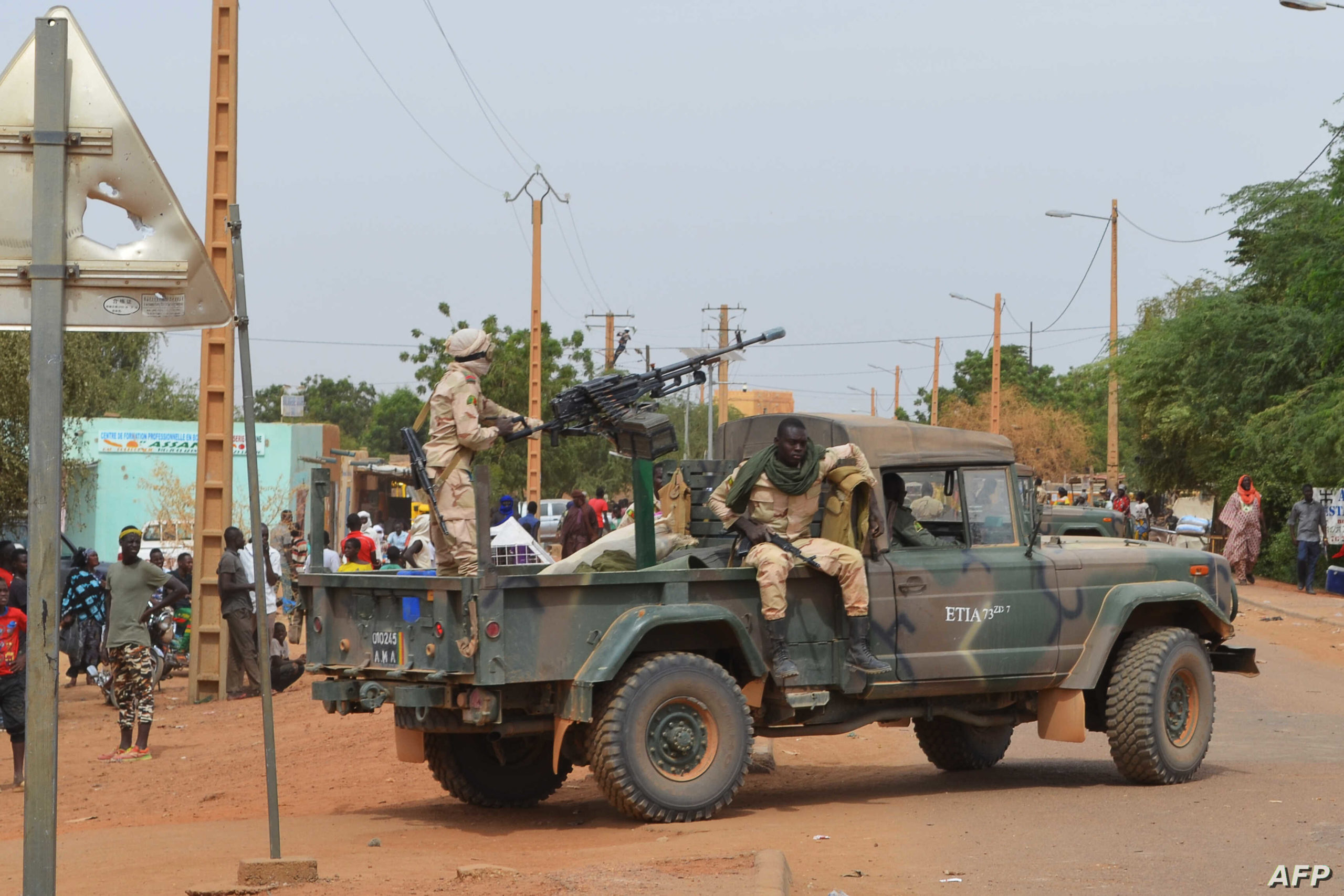 Malian soldiers ride on a pick up truck with a machine gun on November 13, 2018, in Gao