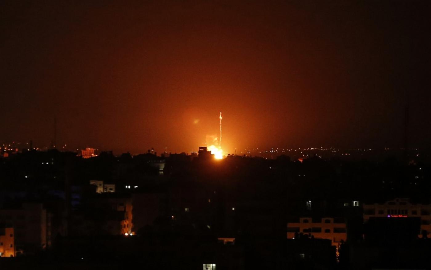 Flames are seen at a distance after Israel carried out airstrikes over Gaza.