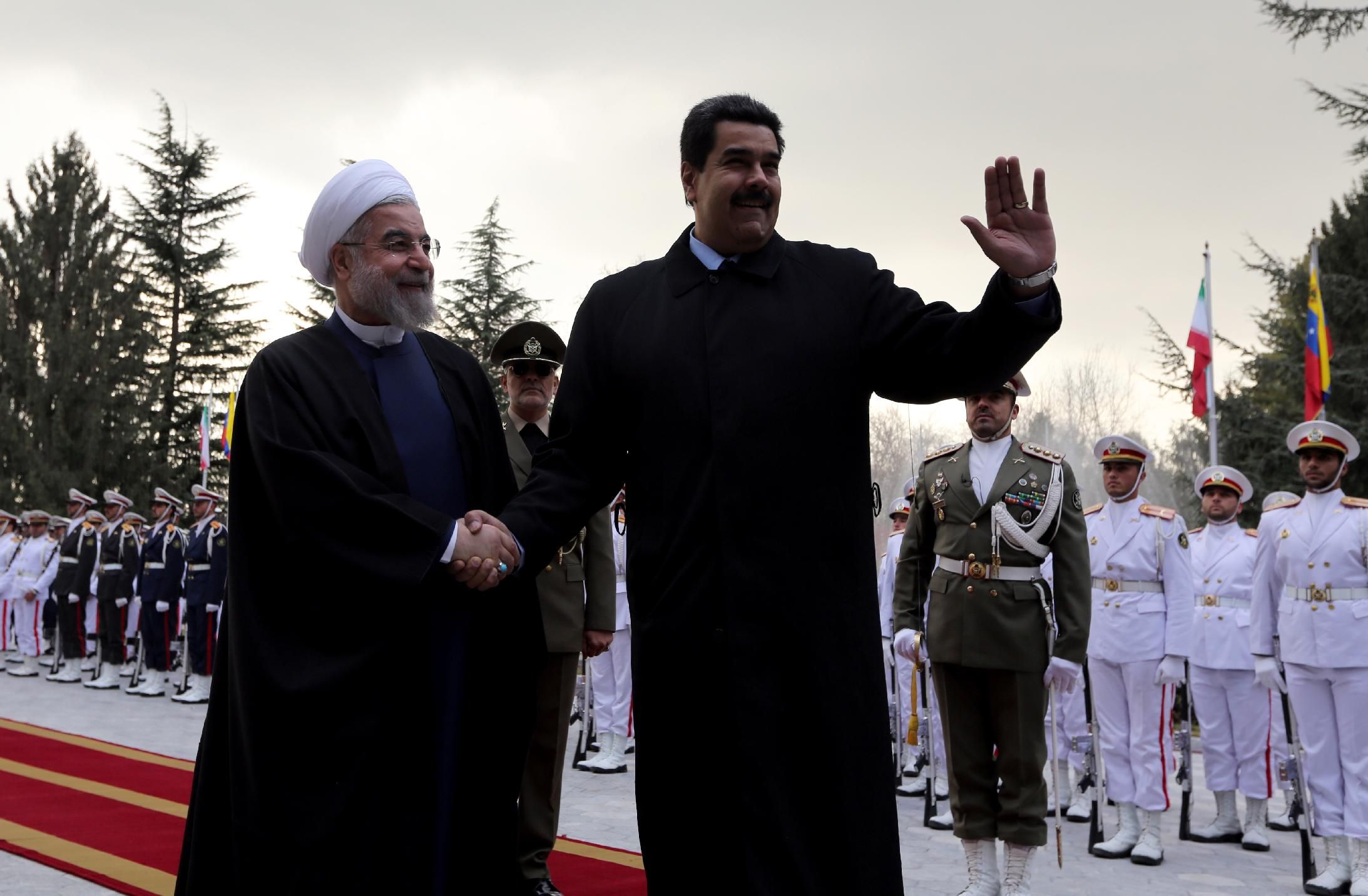 Iranian President Hassan Rouhani (left) shakes hands with Venezuelan President Nicolas Maduro after reviewing the honor guard at the Saadabad Palace in Tehran on January 10, 2015