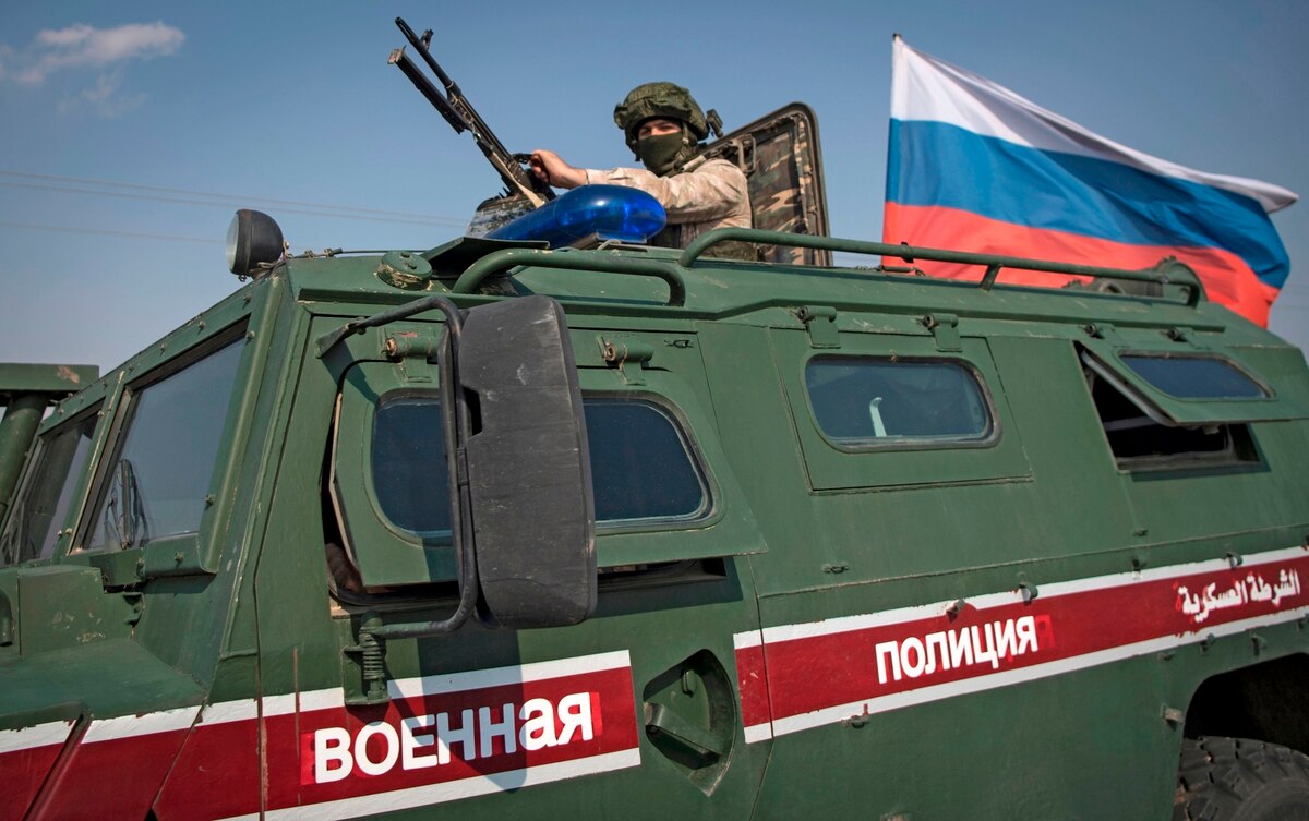A soldier rides atop a Russian military vehicle near the Syrian northeastern city of Qamishli on Oct. 26, 2019.