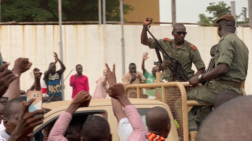 Malian soldiers surrounded by villagers.