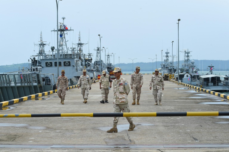 Cambodian navy personnel walk on a jetty at the Ream naval base during a government-organized media tour in July, 2019