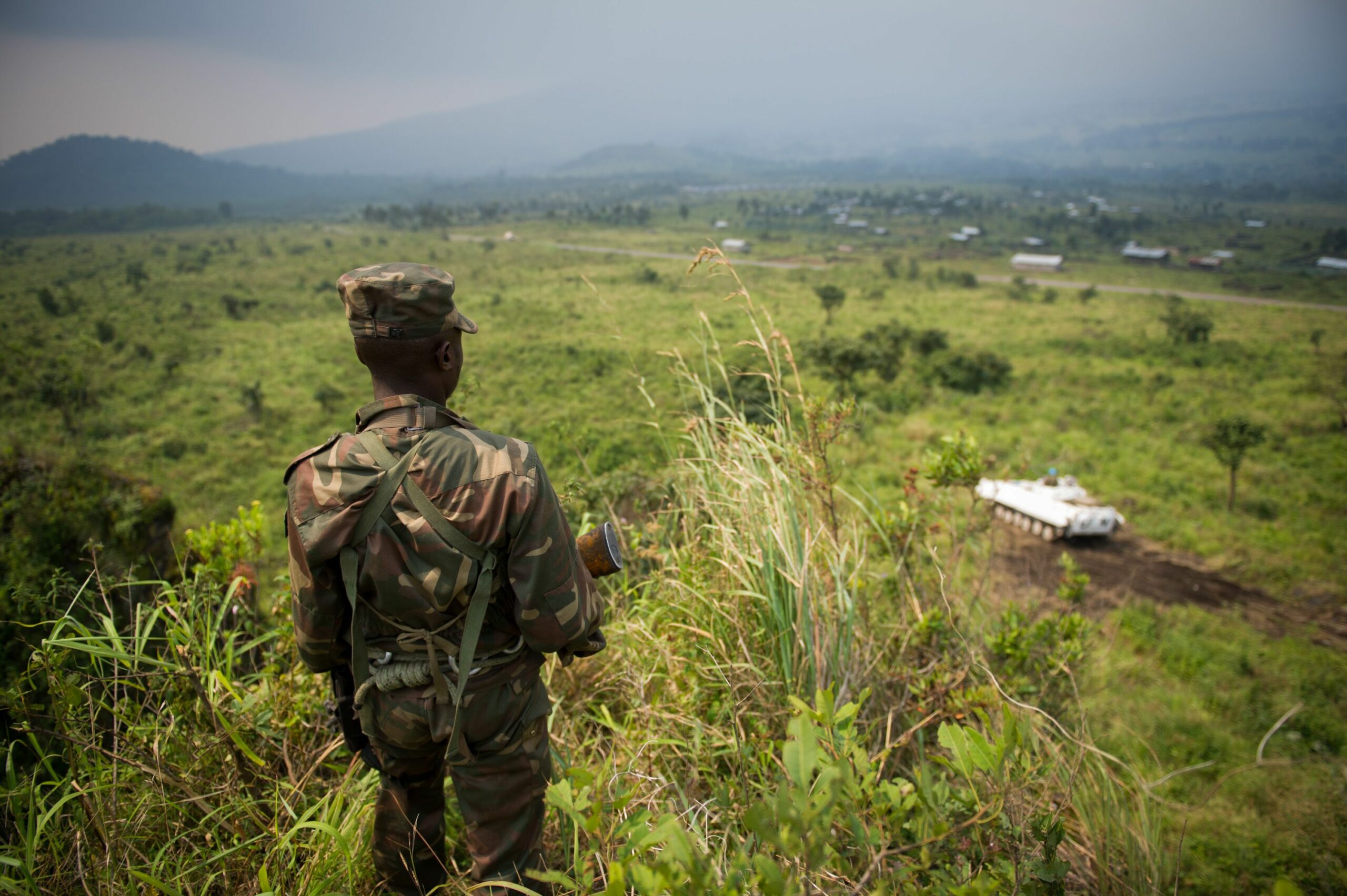 A soldier from the Armed Forces of the Democratic Republic of the Congo (FARDC) stands guard on a hill overlooking a United Nations tank position near the village of Kibumba I, around 20km from the city of Goma in the Democratic Republic of the Congo's restive North Kivu province on July 11, 2012.