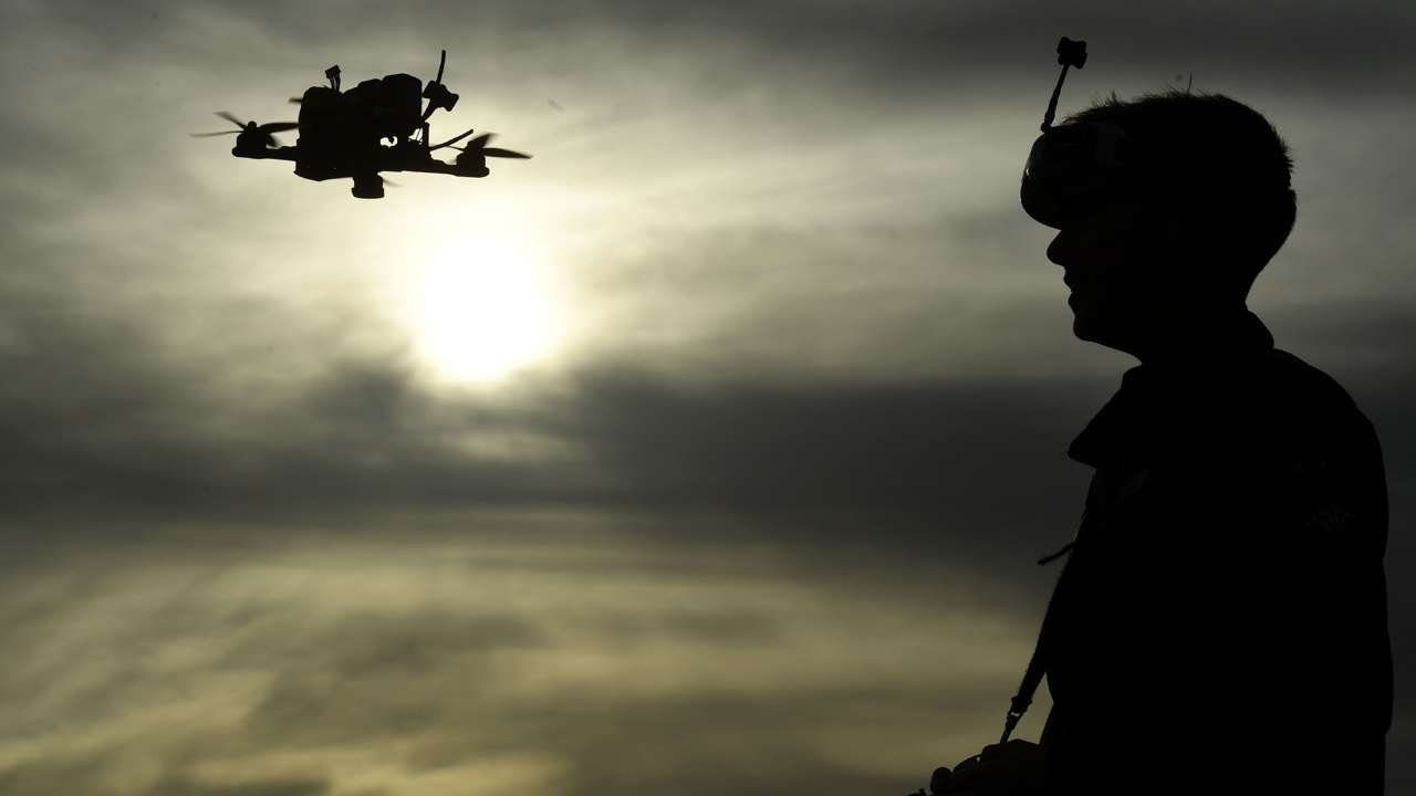 Photo of a man flying a drone.