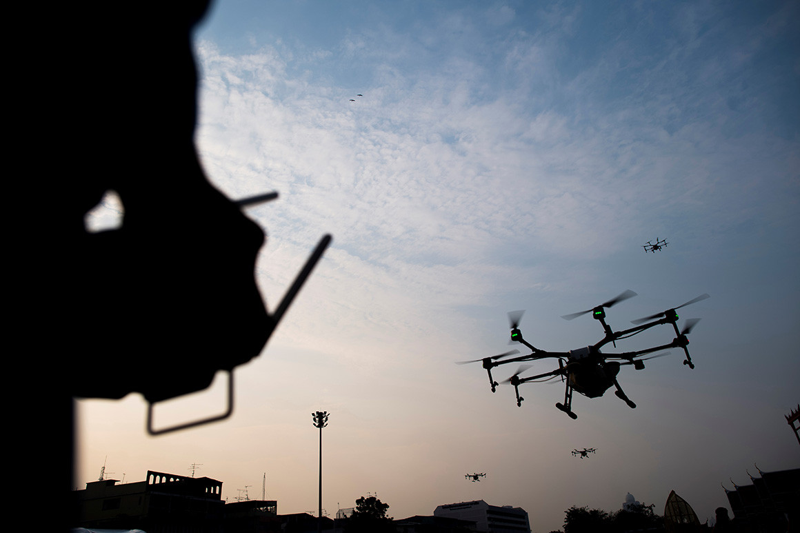Photo of a man flying a drone.