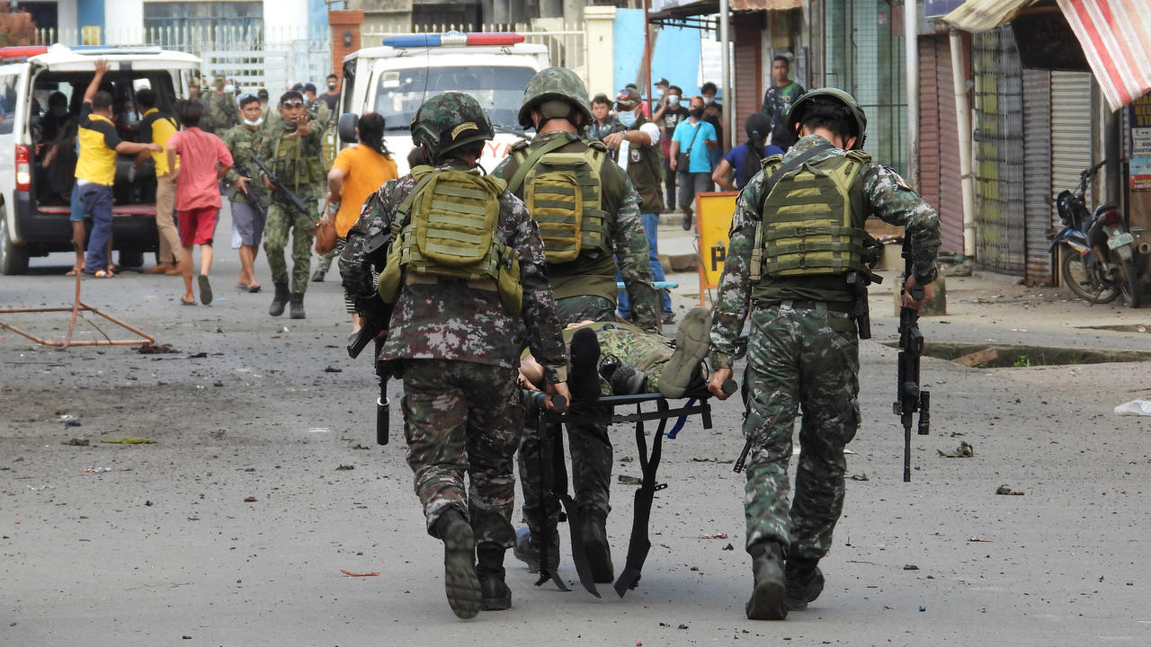 Military personnel carry an injured victim after the twin bombing in Philippines.