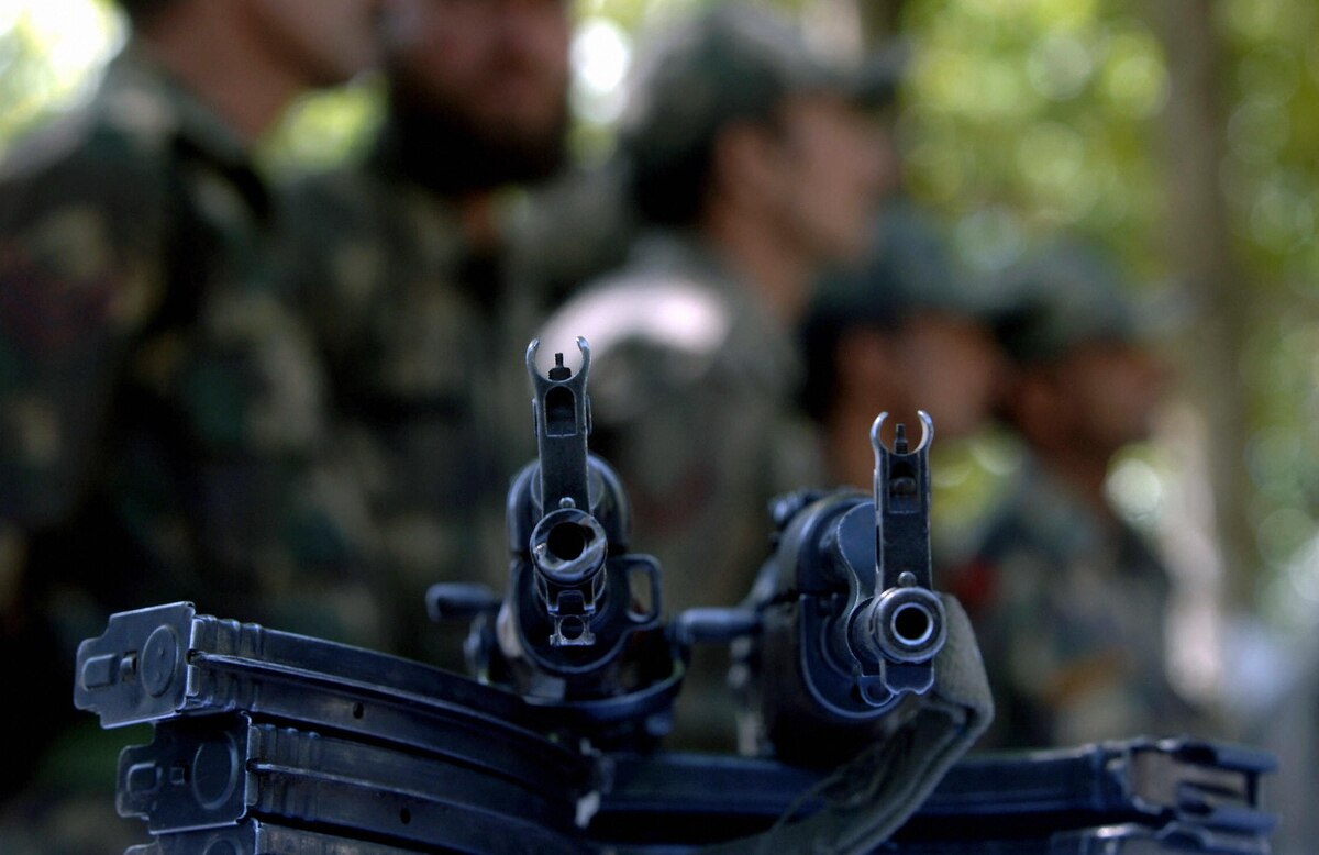 Indian soldiers stand beside a display of AK47 assault rifles