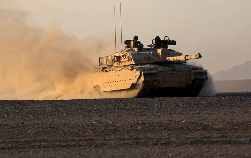 The British Challenger 2 MBT of the 1st Royal Tank Regiment glides effortlessly across soft sand with the low evening light of the Omani landscape glinting off the desert camouflage
