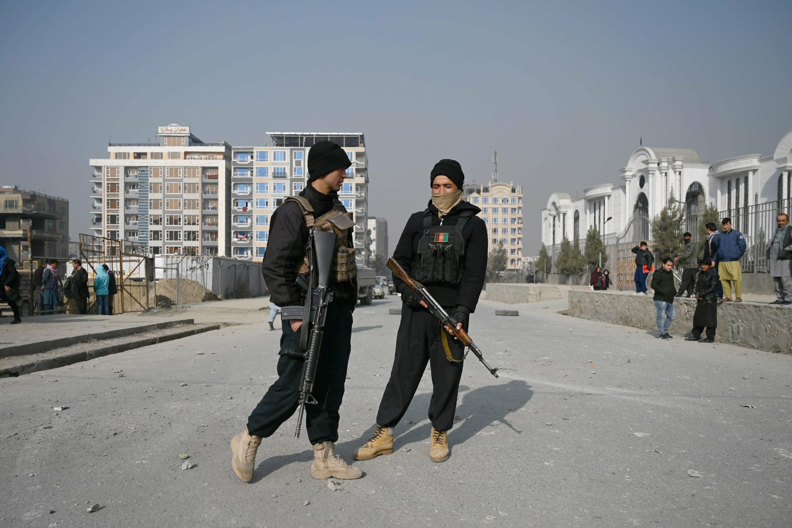 Policemen stand guard at the site of a bomb blast in Kabul on February 2, 2021.