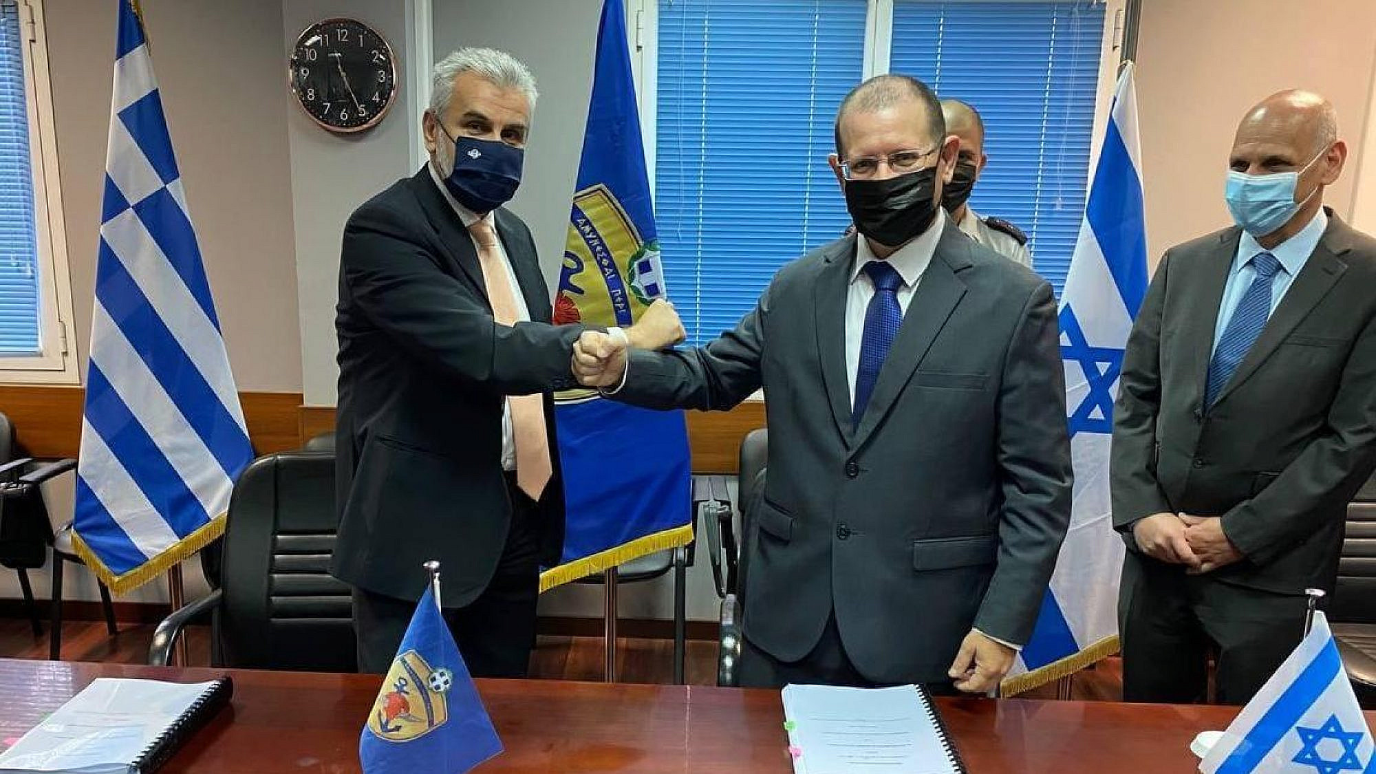 Israel Ministry of Defense official striking a pose concluding deal with Greek official