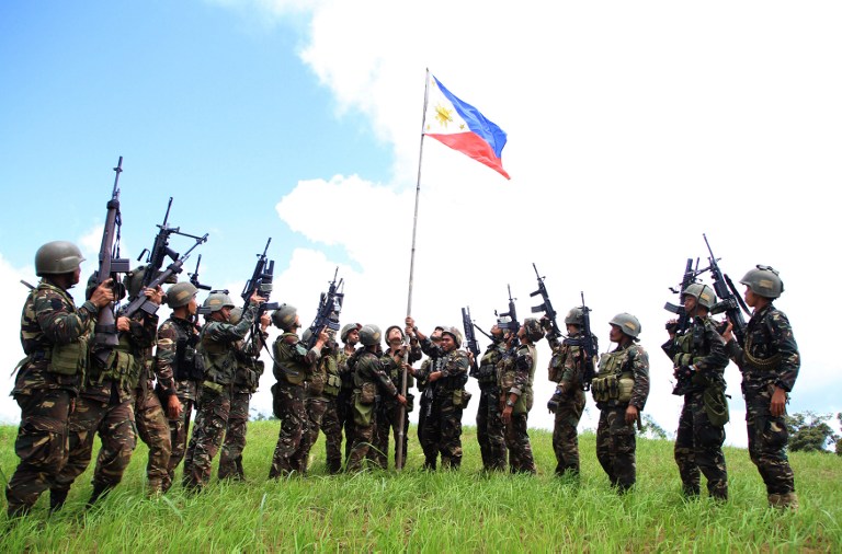 Philippine soldiers seen bannering the country's flag after killing almost 40 militants loyal to Islamic State groups