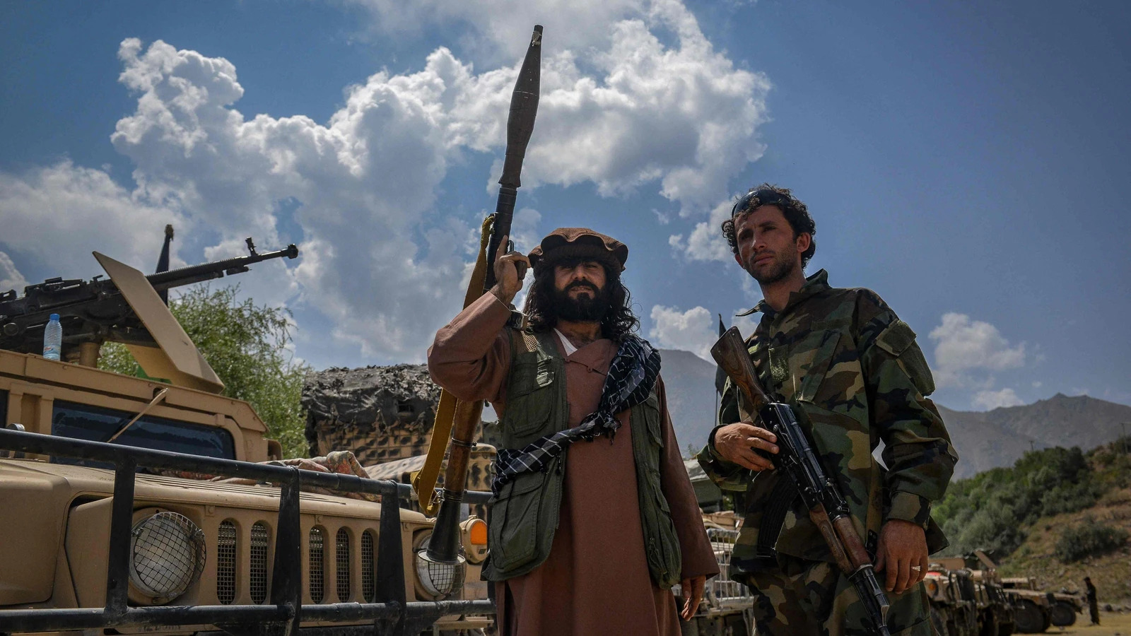Afghan armed men supporting the Afghan security forces against the Taliban stand with their weapons and Humvee vehicles in Panjshir province