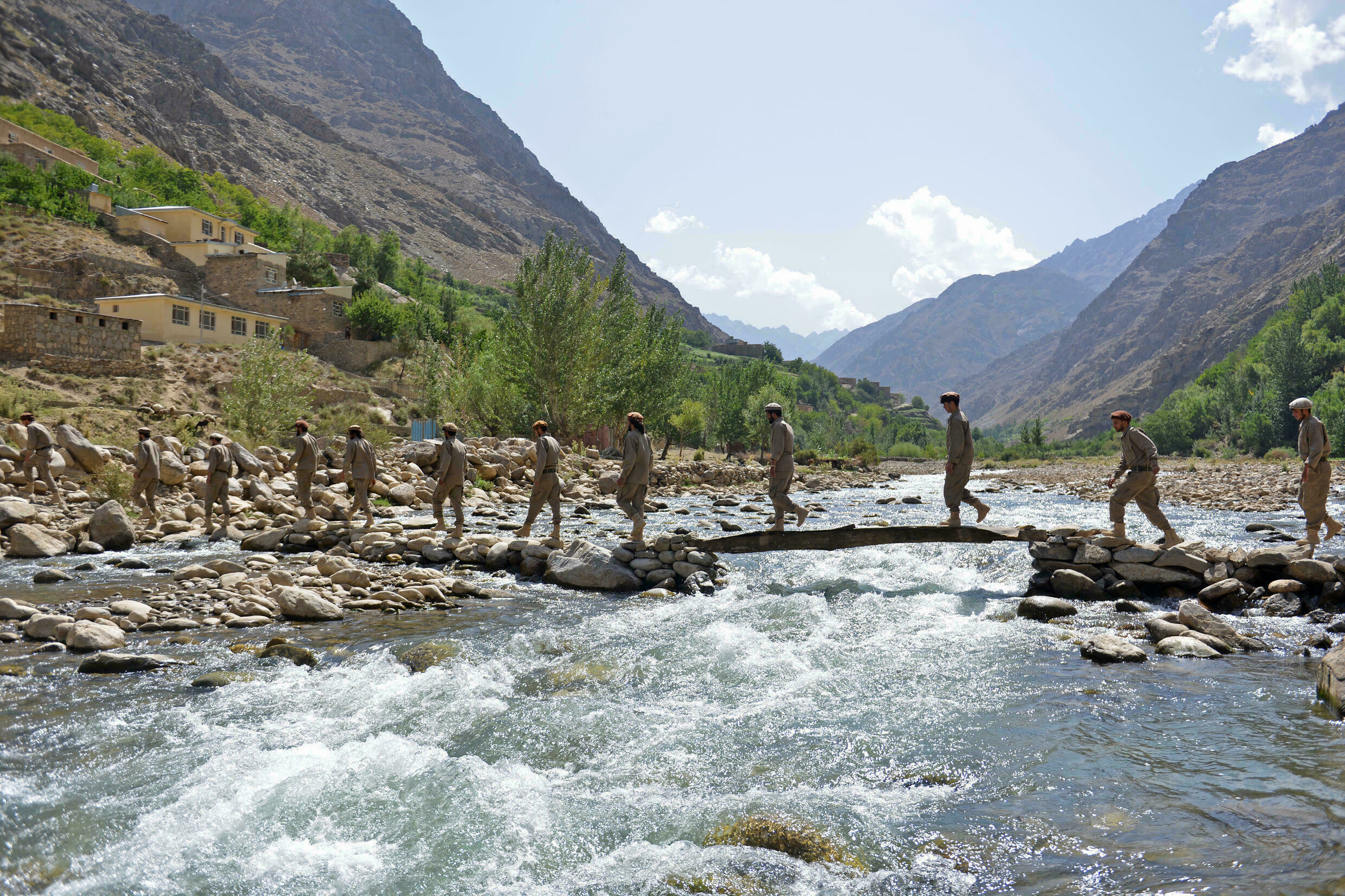 Anti-Taliban fighters crossing a river in the Panjshir valley