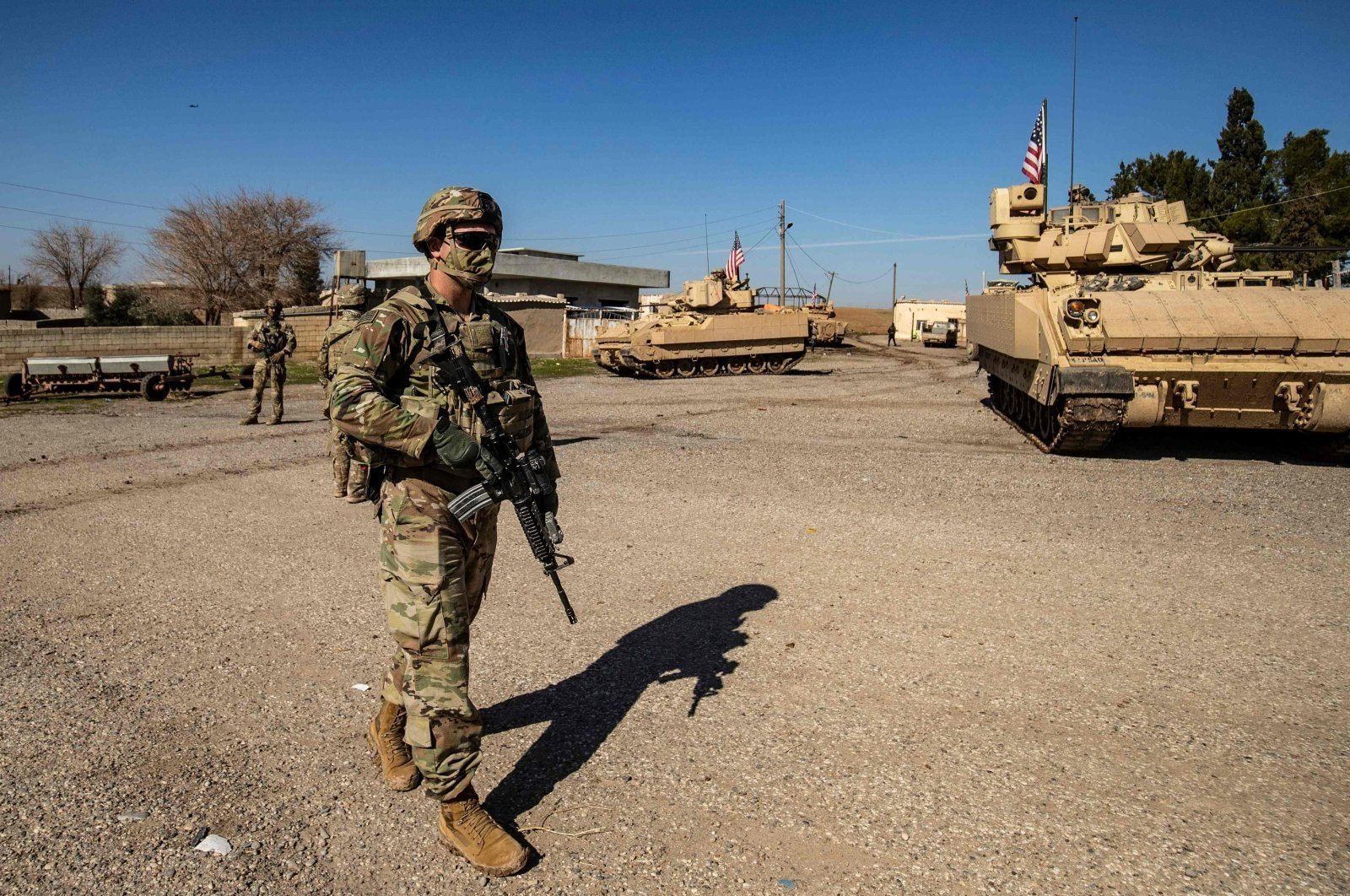 A US soldier walks near a Bradley Fighting Vehicle
