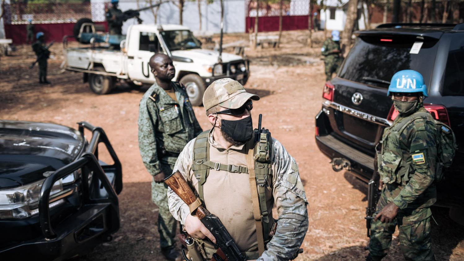 A Rwandan peacekeeper alongside a Russian private security guard