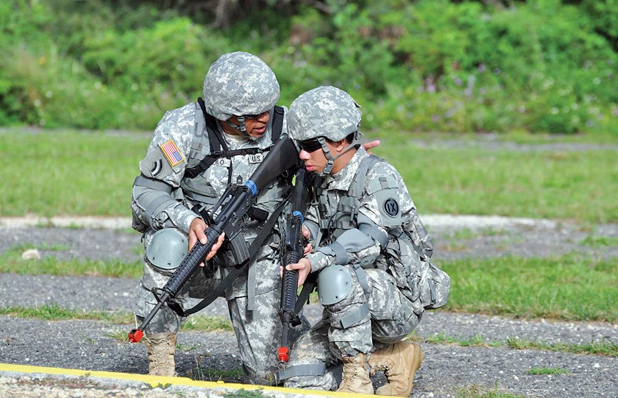 A US Army Master Sergeant provides guidance to a Pvt. during a field training exercise.
