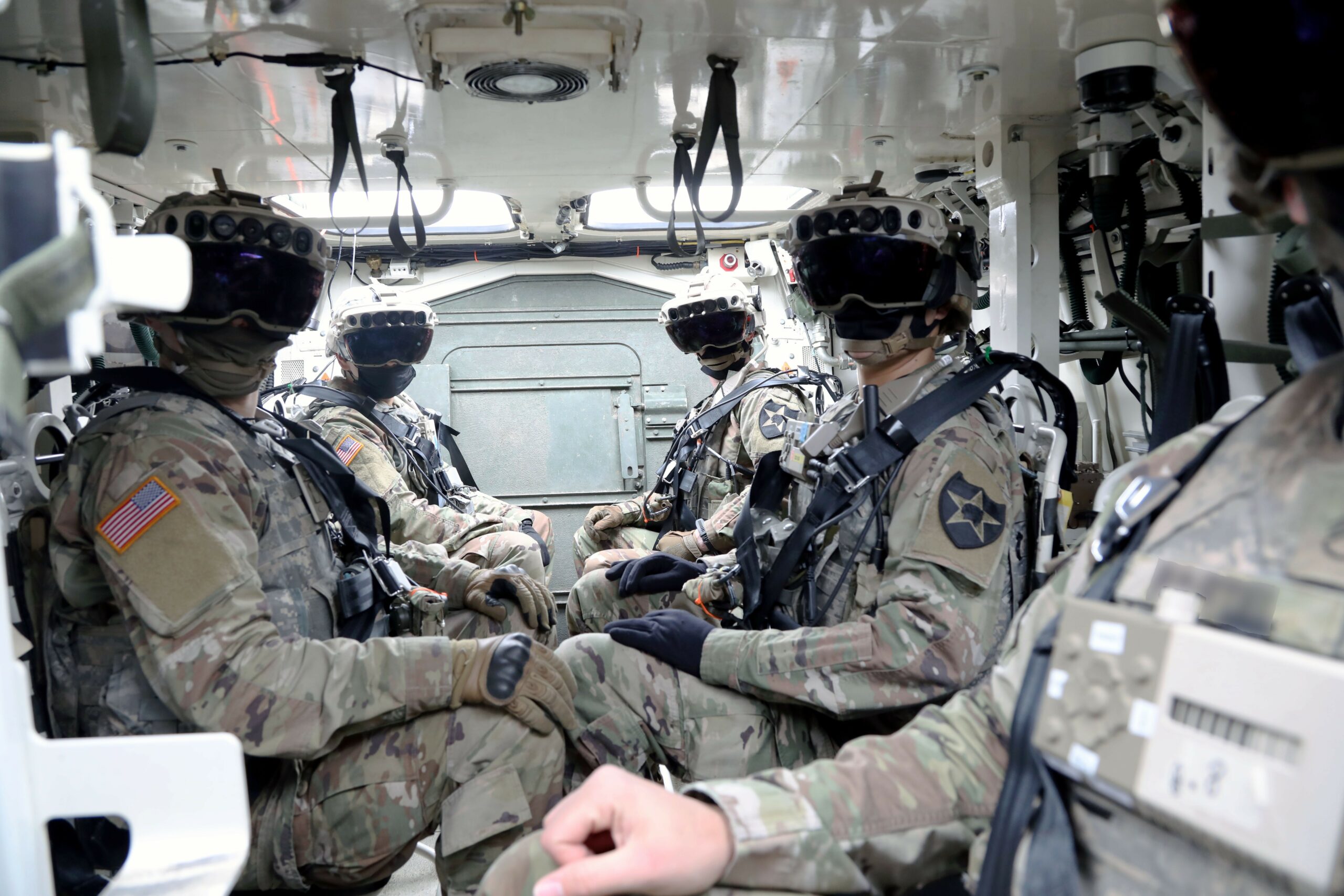 American soldiers wearing the Integrated Visual Augmentation System (IVAS) goggles while inside a Stryker.