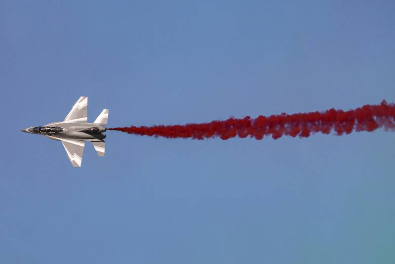 A Chinese Hongdu JL-10 (L-15) supersonic advanced jet trainer and light combat aircraft releases coloured smoke while performing aerial manoeuvres during the 2021 Dubai Airshow