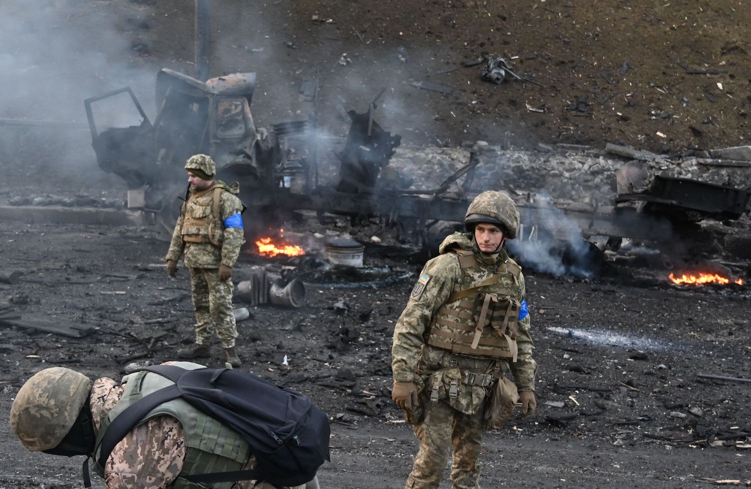 Ukrainian service members look for and collect unexploded shells after a fighting with Russian raiding group in the Ukrainian capital of Kyiv