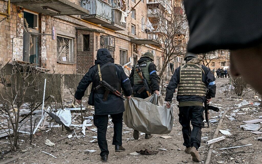 Ukrainian policemen carry a body away from a five-storey building