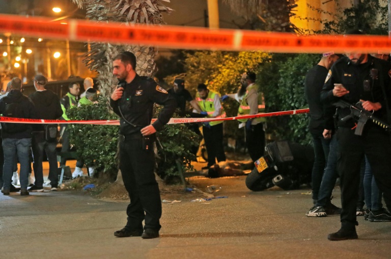 Israeli emergency personnel check the body of an alleged gunman at the scene of a shooting attack in Bnei Brak