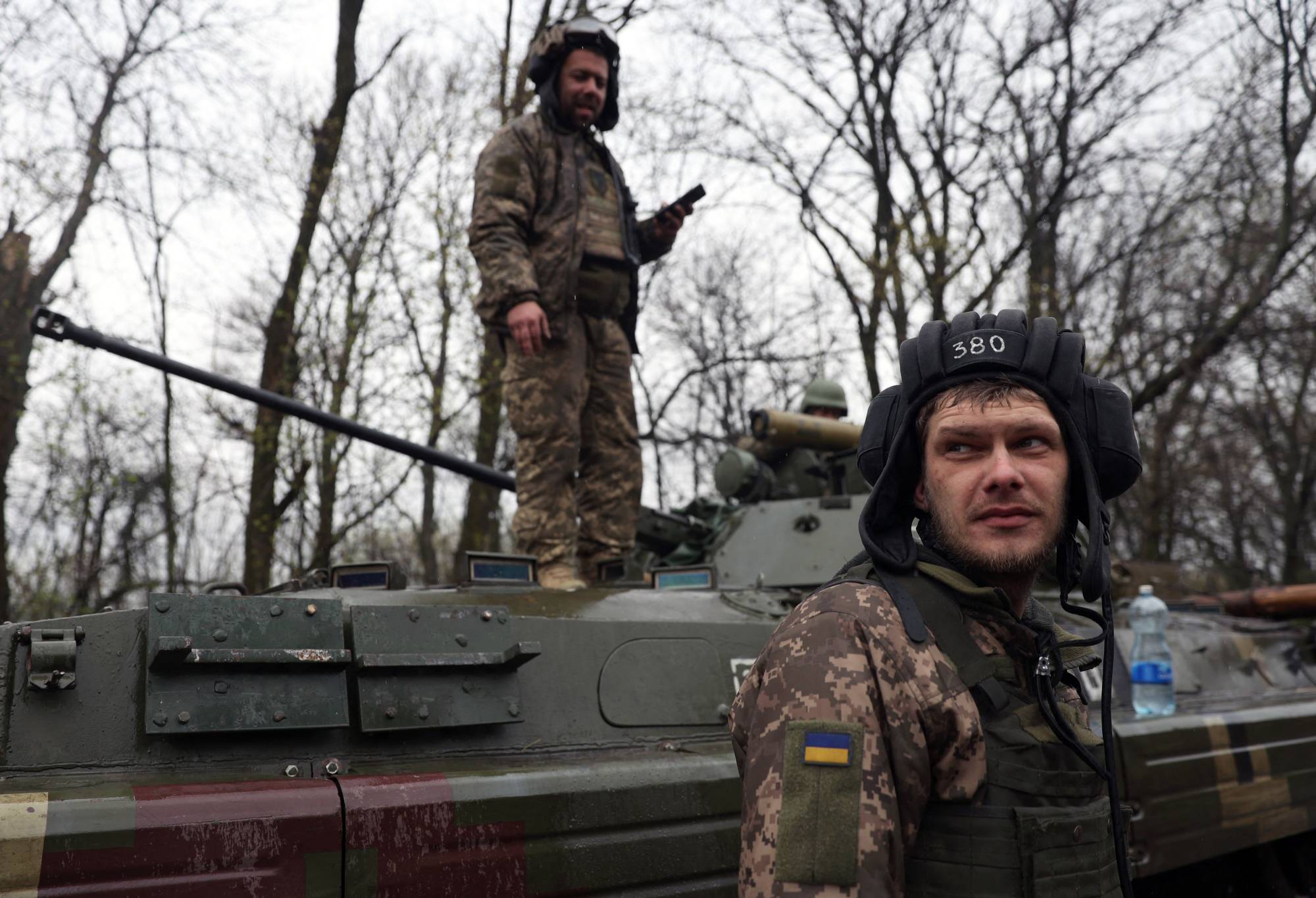 Ukrainian soldiers stand next to their armored personnel