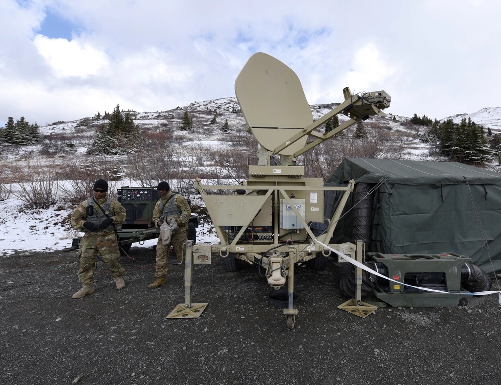 U.S. Army Spc. James Osids (right) and Sgt. Jerrick Thomas from Charlie Company, 307th Expeditionary Signal Battalion calibrate a satellite transportable terminal dish at Site Summit at Joint Base Elmendorf-Richardson, Alaska