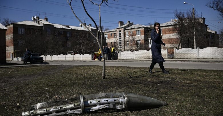 A woman looks at the remains of a missile in Ukraine's Kharkiv