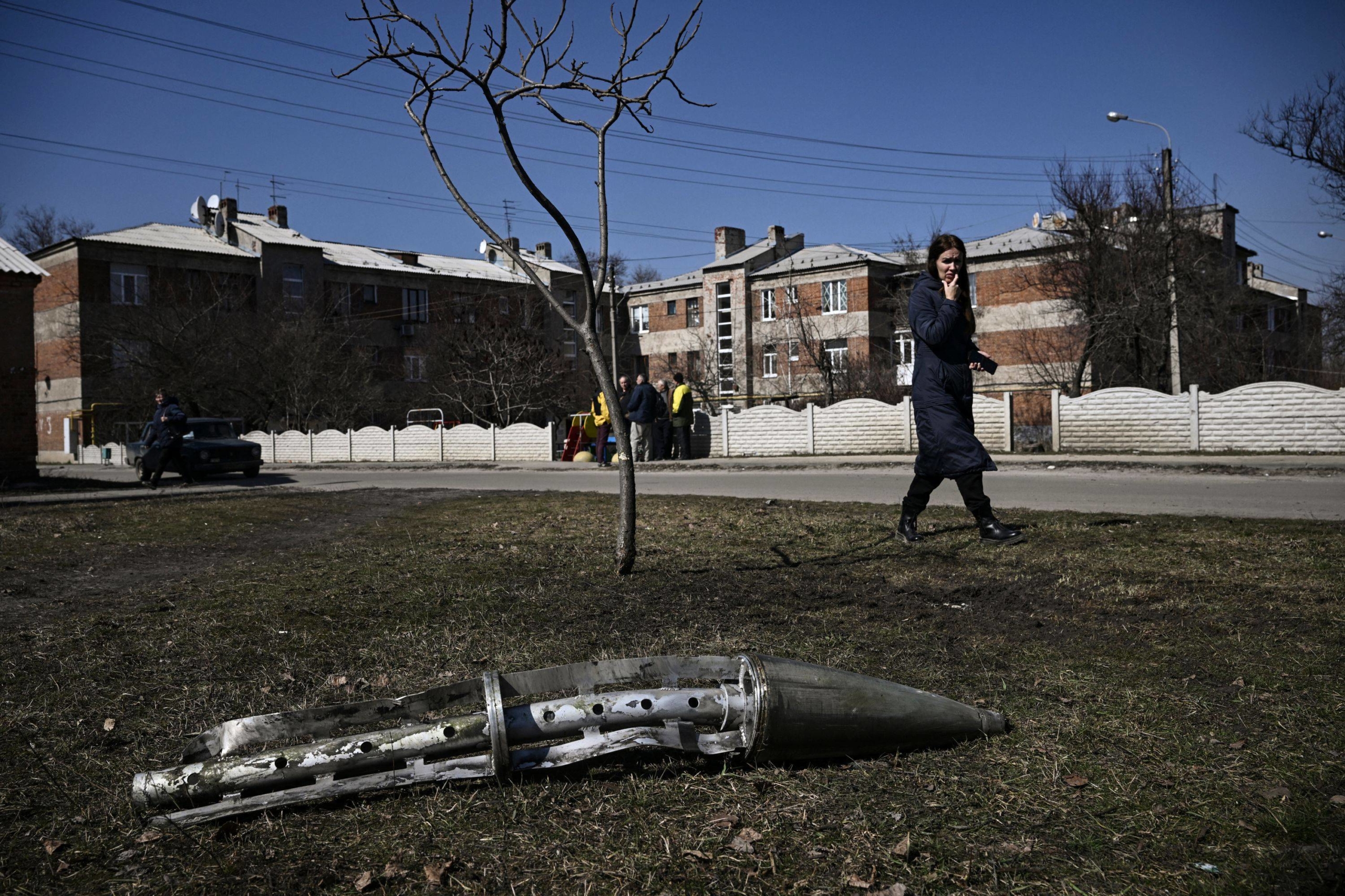 A woman looks at the remains of a missile in Ukraine's Kharkiv
