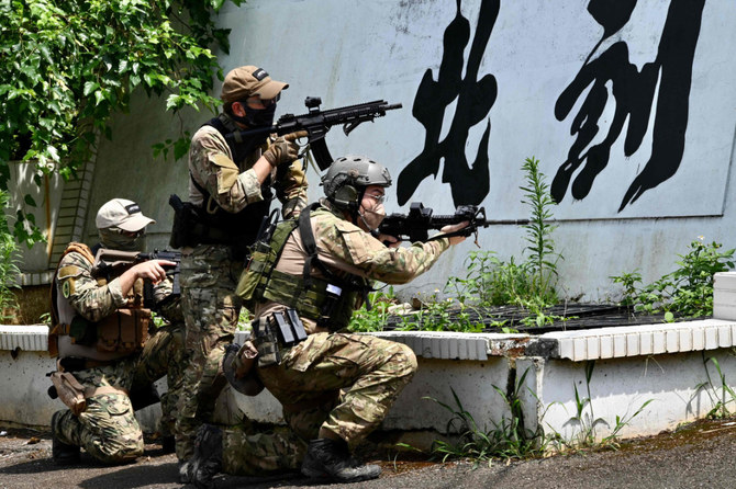 Taiwanese civilians in tactical gear and replica weapons take part in an urban warfare workshop on June 18, 2022