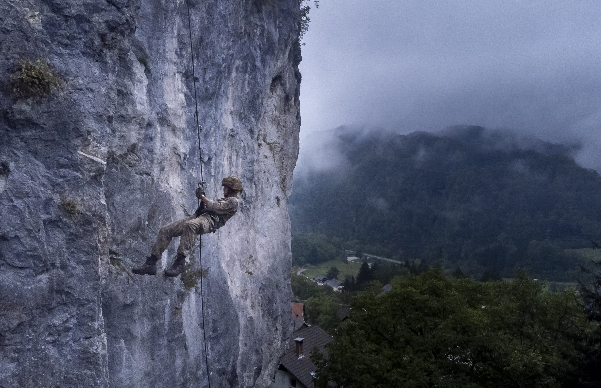 The Parachute Regiment paratrooper abseils down a cliff.
