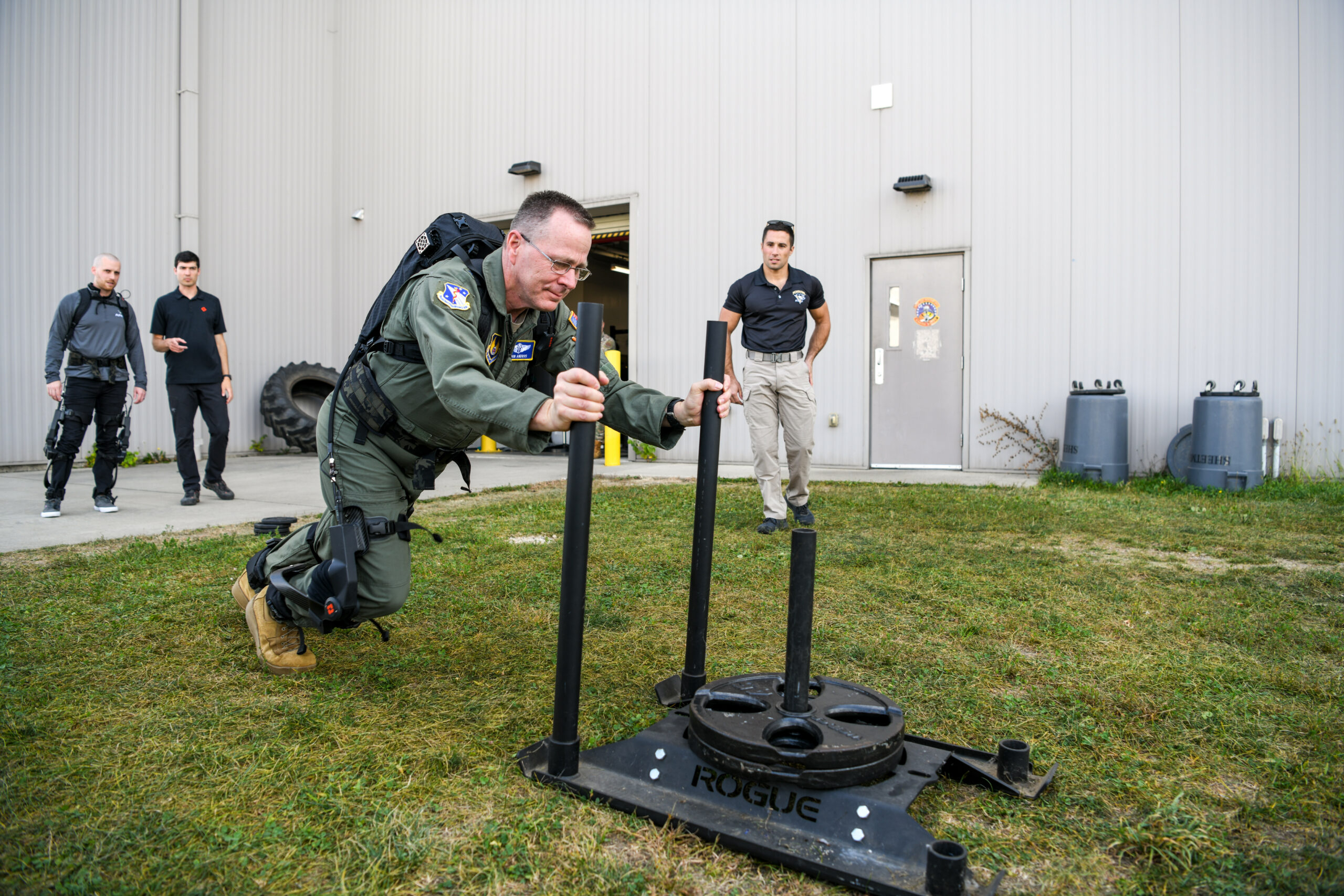 USAF 711th Human Performance Wing commander pushes a weighted sled while wearing the pneumatically-powered exoskeleton